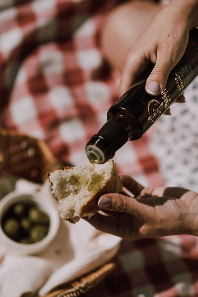 Poring olive oil over bread